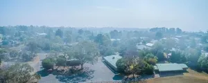 Bushfire Prints: Suburbs in Melbourne in heavy smoke haze brought by wind from bush fires - aerial panorama