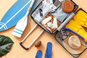 Surfboard Prints: Suitcase with clothes, beach accessories and surfboard on beige background. Travel concept