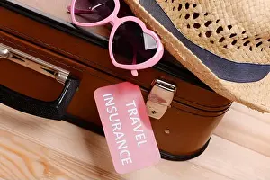 Suitcase Prints: Suitcase and tourist stuff with inscription travel insurance on wooden background