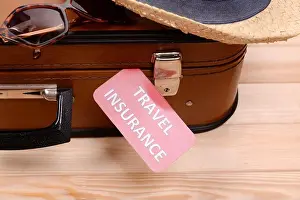 Suitcase Prints: Suitcase and tourist stuff with inscription travel insurance on wooden background