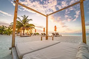 Summer beach landscape. Luxury vacation and holiday concept, summer travel banner. Panoramic landscape of sunset beach, two loungers umbrella, palms