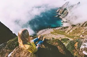 Backpacker Prints: Summer vacations in Norway travel woman tourist relaxing alone on mountain cliff over ocean active lifestyle hiking