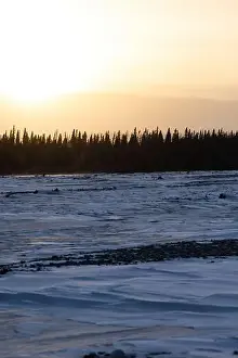 Delta Junction Prints: Sun above mountains behind a frozen river on a winter day in interior Alaska