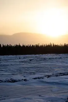 Delta Junction Prints: Sun rising over mountains behind frozen river on the winter solstice in interior Alaska