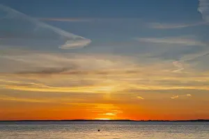 Cirrus Prints: The sun about to set over the Welsh coast with a reddish orangey glow along the horizon