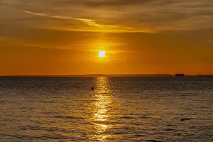 Sky Landscape Prints: The sun setting over the Welsh coast sending a streak of Sunlight across the sea