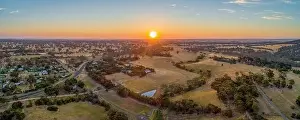 Beautiful Sky Prints: Sun touching the horizon at sunset over Australian outback - wide aerial panorama