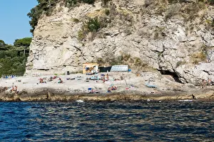 Sunbathers Prints: Sunbathers enjoy a rugged rock beach along the Sorrento coast, Compania, Italy