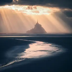 Dreamlike Prints: Sunlight over silhouette of Mont Saint Michel sanctuary, Normandy, France