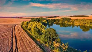 Sunny summer sunset on outskirts of Ternopil town with small pond