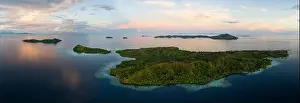 Sunrise illuminates clouds that drift over the calm waters of the Solomon Islands. This scenic region is known for its high marine biodiversity