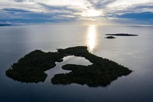Aerial Landscape Collection: Sunrise illuminates a remote island and lagoon off the coast of New Britain, Papua New Guinea