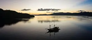 Raja Ampat Prints: Sunrise silhouettes a diving live aboard ship in Raja Ampat