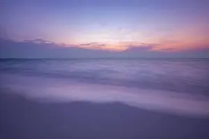 Sunset Landscape Prints: Sunset coastline seascape. Peaceful beach sand with calm sea view