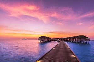 Images Dated 4th January 2017: Sunset landscape on Maldives island beach, water villas resort. Beautiful sky and clouds