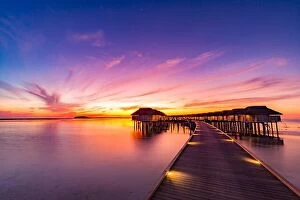 Images Dated 12th January 2017: Sunset on Maldives island, luxury water villas resort and wooden pier. Beautiful sky and clouds