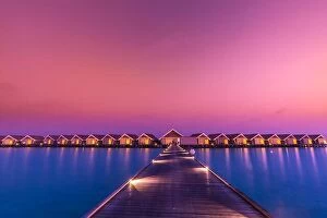 Images Dated 7th January 2017: Sunset on Maldives island, luxury water villas resort and wooden pier. Beautiful sky and clouds