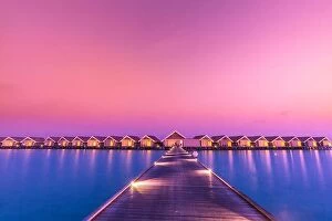 Images Dated 7th January 2017: Sunset on Maldives island, luxury water villas resort and wooden pier. Beautiful sky and clouds
