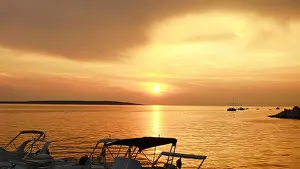 Sunset on the sea with dramatic sky in beige color tone and silhouette of boats