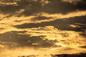 Time Lapse Prints: Sunset sky with golden rays of the sun against the background of silhouettes of mountain landscapes and rural villages