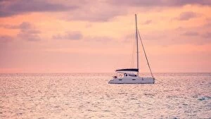 Images Dated 18th December 2015: Sunset views at the sea with a yacht or silhouette of catamaran. Luxury travel and tourism vacation