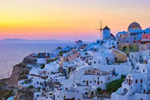 Cyclades Prints: sunset with white churches an blue domes by the ocean of Oia Santorini Greece