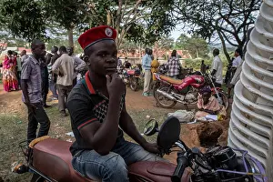 Supporter Prints: A supporter of Bobi Wine poses wearing the red beret associated with the 'people power' during a campaign