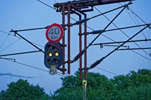 Gantry Prints: A suspended railway signal shows a steady yellow aspect with a speed limit board reading forty kmh