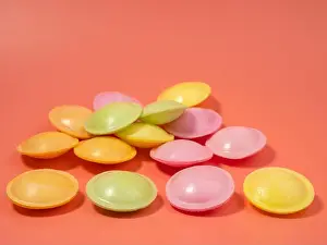 Saucer Prints: Sweet candies in the shape of a UFO in different colors on a pink background