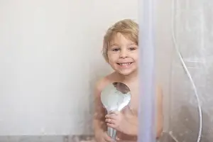 Taking Prints: Sweet toddler boy in bathroom, taking shower, smiling happily at the camera