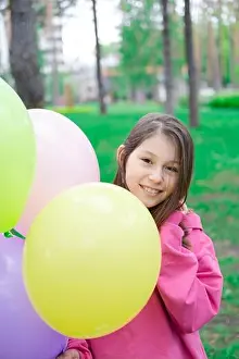 Tween Prints: sweet tween brunette girl in pink holding colorful balloons outdoors