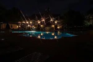 Parasols Prints: A swimming pool lit up for a night swim