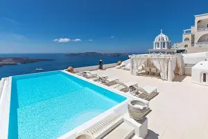Swimming poolside, infinity pool relaxation view out over the sea caldera of Santorini Greece. Luxury travel, summer holiday vacation, peaceful resort