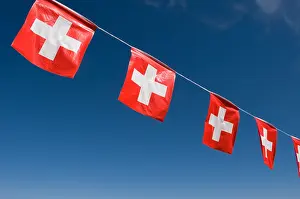 Cross Shape Prints: swiss flags in a row against blue sky