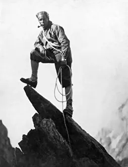 1925 Prints: Switzerland: c. 1925. A mountaineer takes a break on a pinnacle of Mount Matterhorn