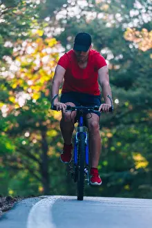 Offroad Prints: Tall handsome biker rides his bicycle on sunset in a lovely magical forest