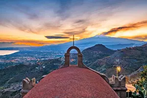 Taormina, Sicily, Italy with the ancient Church of San Biagio and Mt. Etna at dusk