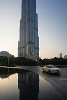 A taxi passes by the Burj Khalifa tower in Dubai, United Arab Emirates