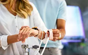 Choosing Prints: Technology people smart devices concept. Happy couple buying new smart watch in tech store