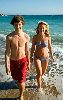 Teens Prints: Teenage boy and girl walking out of sea