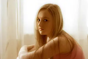 16 Year Old Prints: Teenage girl with blonde hair, sitting in front of net curtains in window