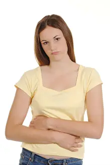 Teenage Girl Prints: a teenage girl holding her stomach looking in pain
