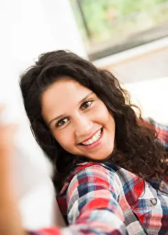 Curly Hair Prints: Teenage girl smiling and posing, taking selfie with smart phone, Germany