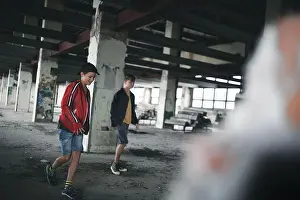 Mischief Prints: Teenagers boys indoors in abandoned building, walking