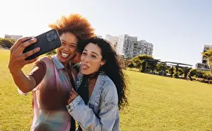 Curly Hair Prints: Two teenagers taking a playful selfie outdoors