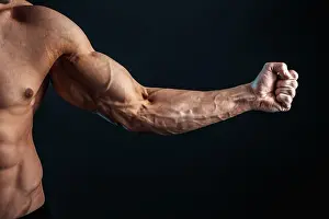 Isolate Prints: tense arm clenched into fist, veins, bodybuilder muscles on a dark background, isolate