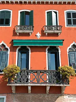 Railings Prints: Terracotta orange red rendered Venetian house facade with ornate balconies and green window shutters