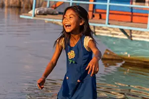 Sapa Prints: Thakhek, Laos - April 19 2018: Happy girl playing near the water in a remote rural area of Laos