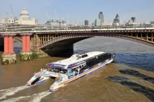 Promoting Prints: 'Thames clipper' fast riverboat service passing under Blackfriars railway bridge shows extensive Nat West