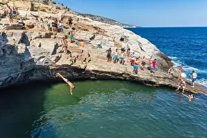 Thassos, Greece - July 20, 2019: Tourists are doing diving in the natural swimming pool Giola in Thassos island, Greece
